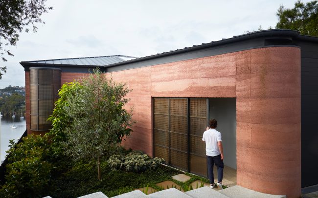 Solid, yet discreet rammed earth street entry façade