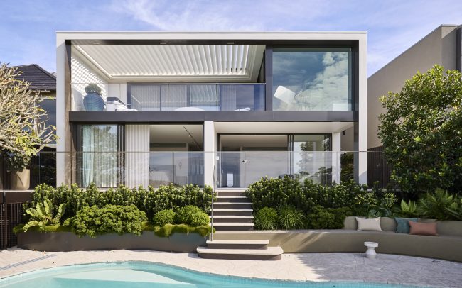 The rear elevation invites the water views throughout the home, into the bedroom spaces on the lower level and across the living spaces on the upper level